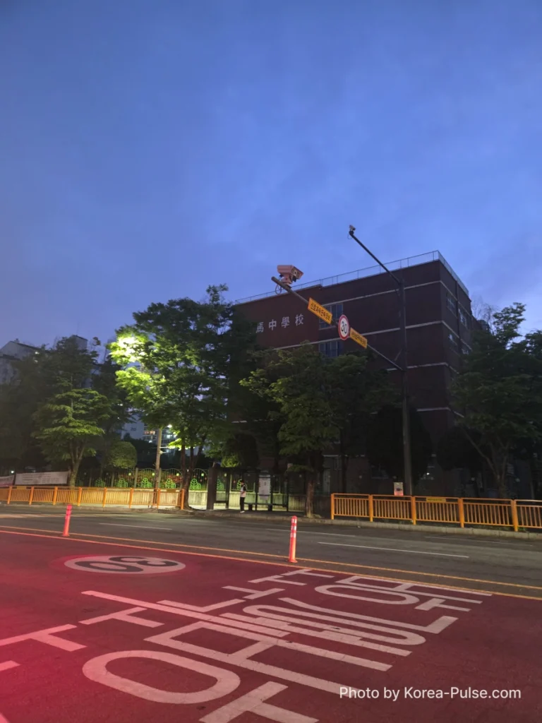 BTS Is Back: A Global Dad's Perspective from the Heart of Seoul 8 Oma Middle School building at dusk, with a school-zone road marking painted in red on the street in front