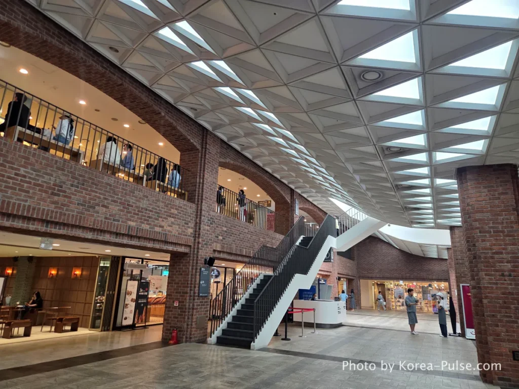 Myeongdong Cathedral: Seoul's Gothic Soul, Hidden Above the Shopping District 3 Interior of 1898 Plaza underground complex beneath Myeongdong Cathedral — wide corridor with modern brick walls and natural lighting