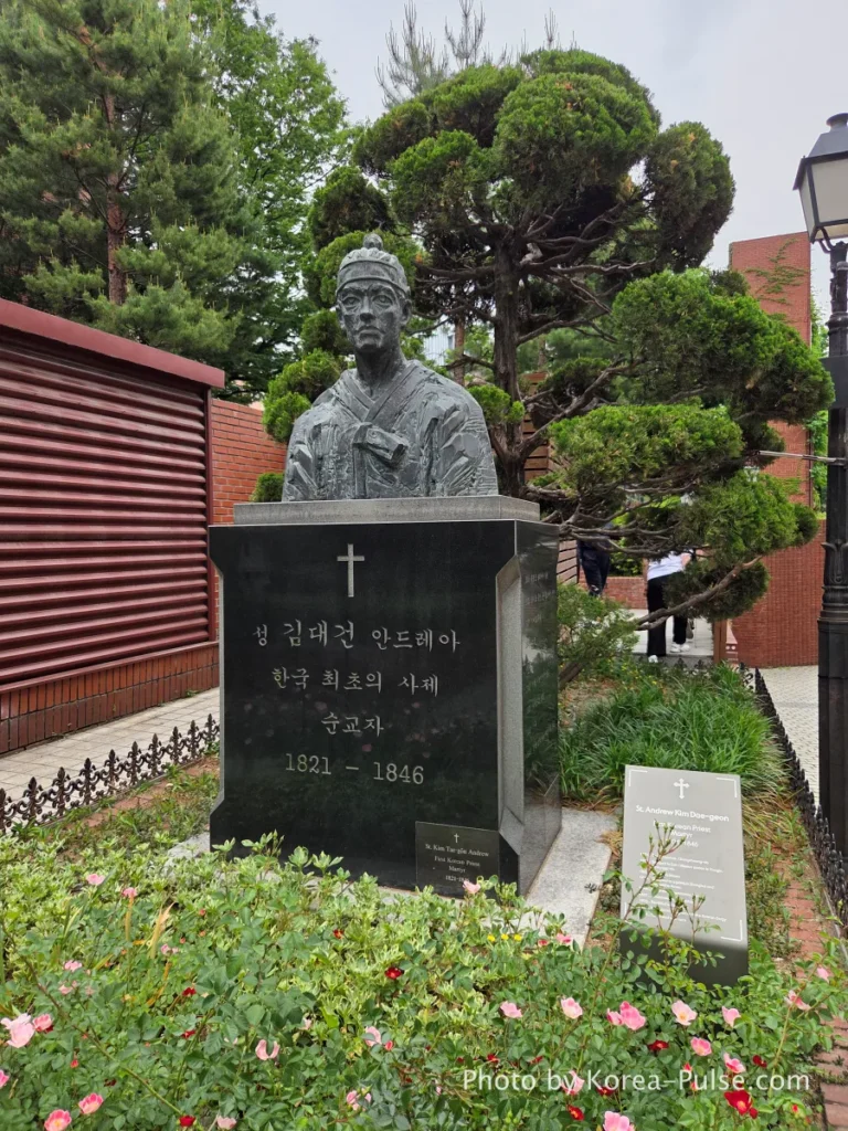 Myeongdong Cathedral: Seoul's Gothic Soul, Hidden Above the Shopping District 14 Bronze statue of Saint Andrew Kim Taegon — first native Korean Catholic priest — in the garden of Myeongdong Cathedral Seoul