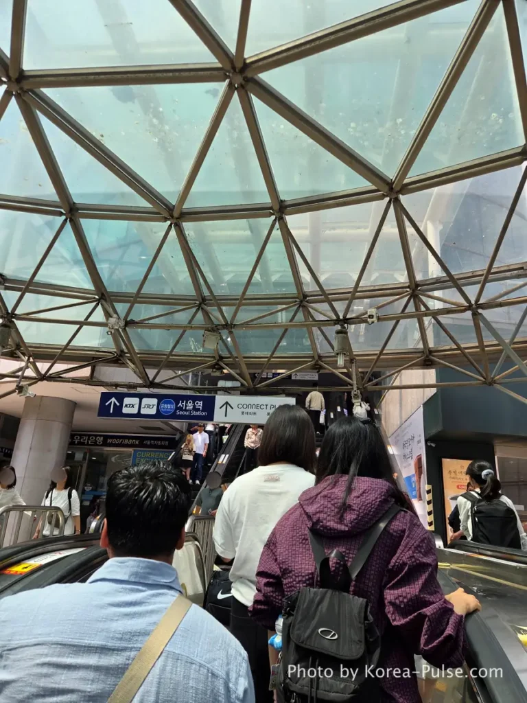 GTX-A Seoul Guide: Korea's Deep Underground Express from Daegok to Seoul Station 12 Escalator rising toward the glass dome ceiling at Seoul Station with natural light streaming in from above