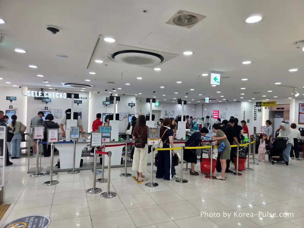 Daiso Myeongdong Station branch 1st floor checkout counter area crowded with shoppers Seoul