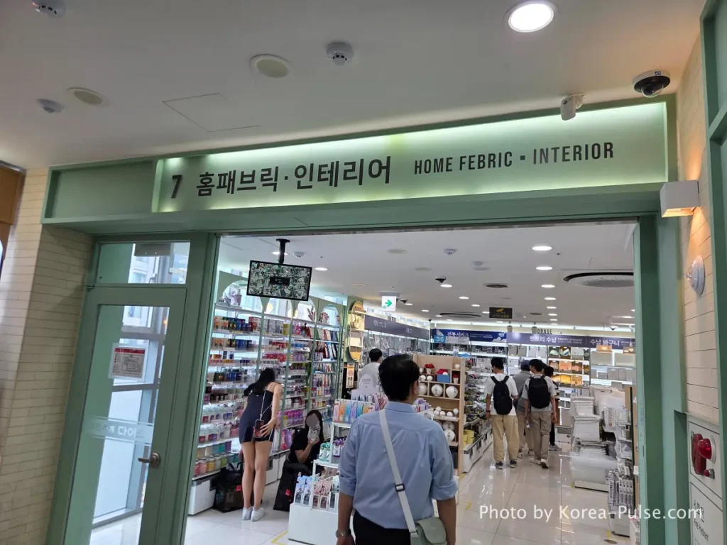 https://korea-pulse.com/wp-content/uploads/2026/05/20260526_122228.webp" alt="Daiso Myeongdong Station branch 7th floor home fabric and interior section entrance sign Seoul