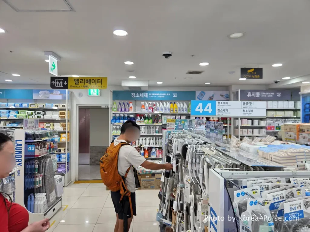 Cleaning supplies bathroom products and laundry items display aisle on 8th floor Daiso Myeongdong Station branch Seoul