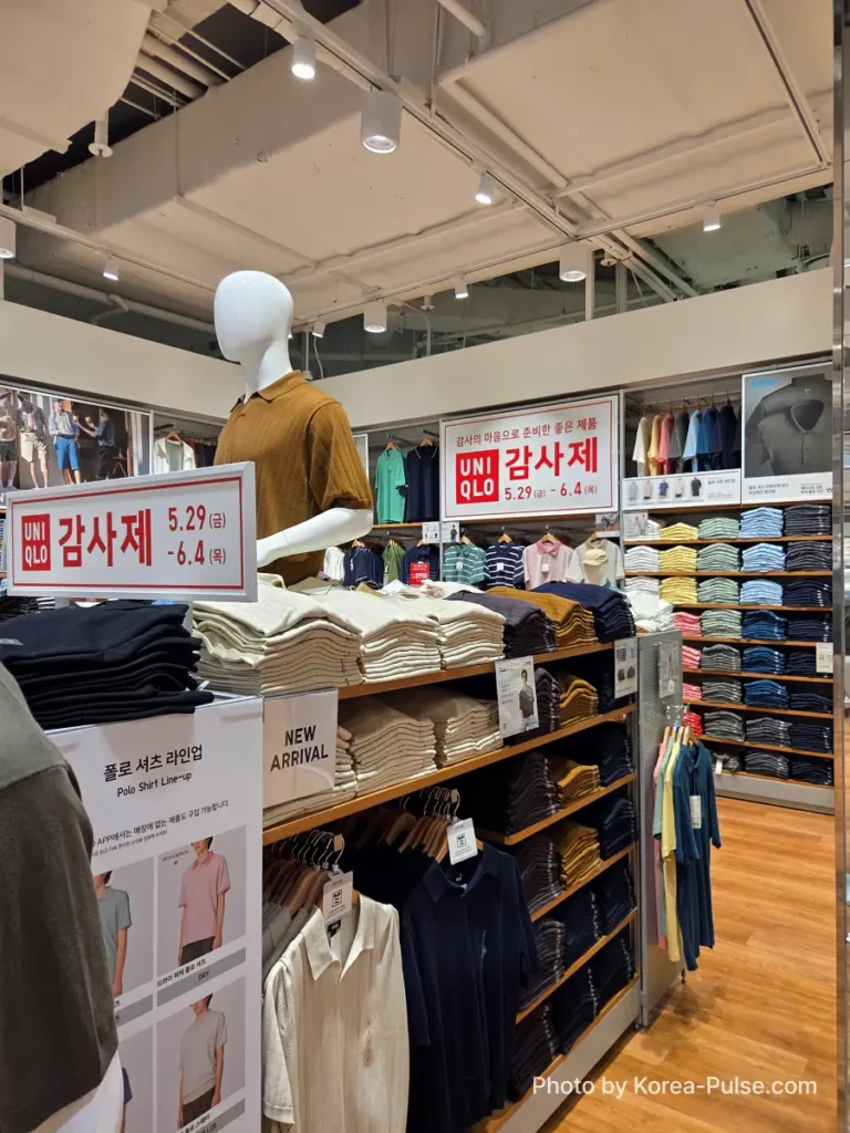 Inside a Uniqlo Seoul store on the opening day of the Gamsaje, Uniqlo Thank You Festival, with red promotional banners reading 감사제 5.29~6.4 and a mannequin dressed in a polo shirt