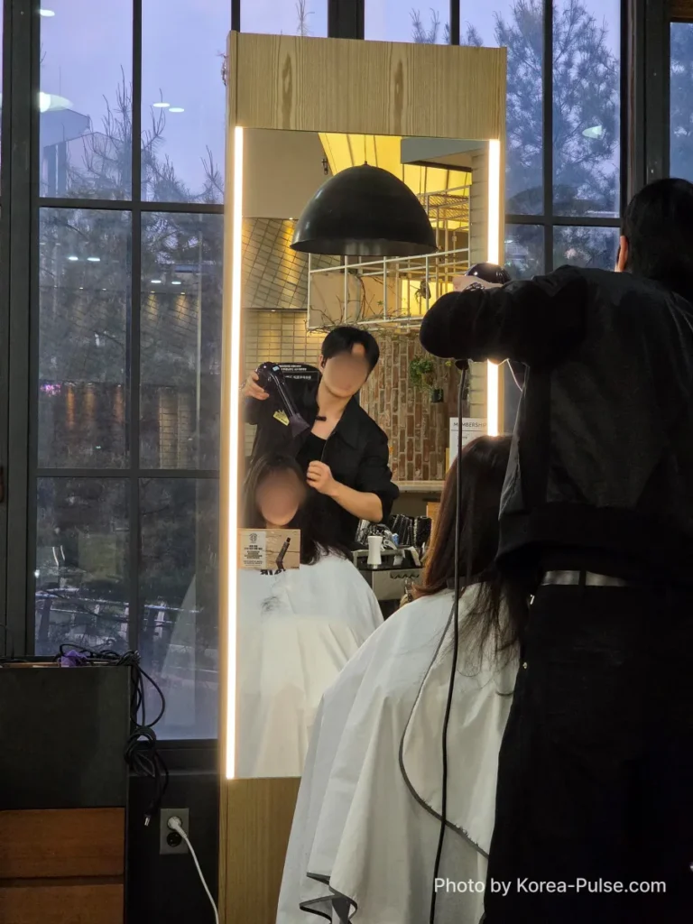 Professional hair designer at idHAIR One Mount performing a styling treatment