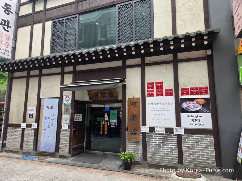 Full exterior view of Hadongkwan restaurant building in Myeongdong Seoul — traditional Korean architecture in a commercial district

