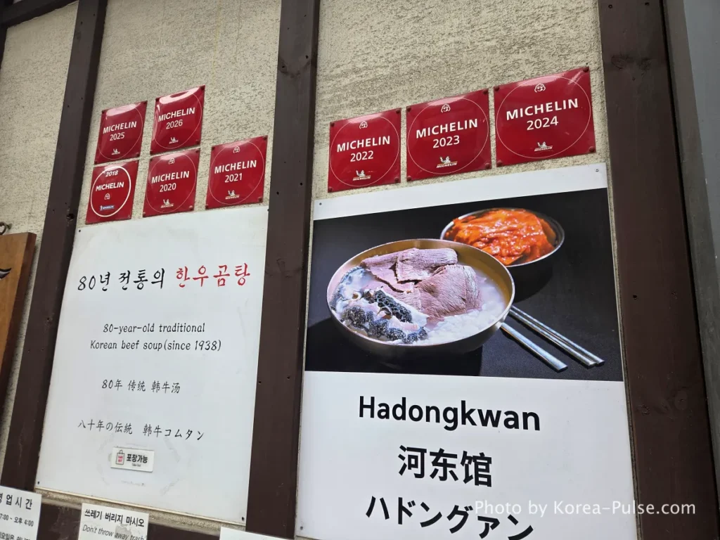 Wall of Hadongkwan restaurant in Myeongdong covered in Michelin Guide plaques from 2018 to 2026 alongside multilingual signage