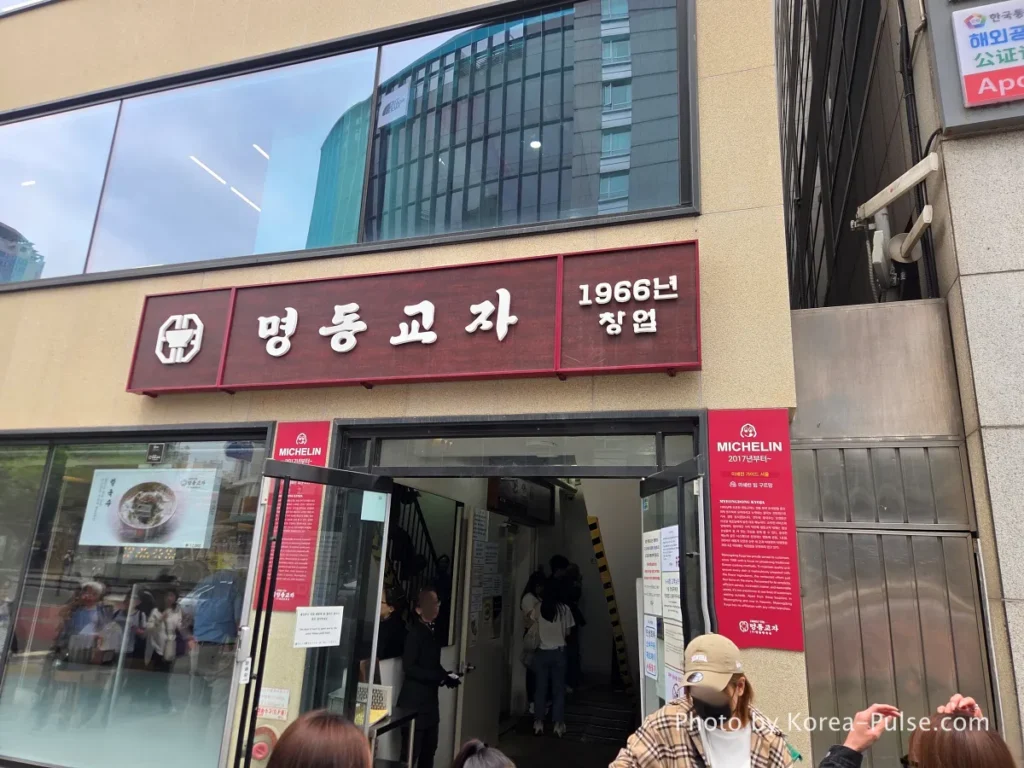 Myeongdong Kyoja restaurant entrance with red signage showing established 1966 and Michelin Bib Gourmand plaques from 2017 onwards [Myeongdong street]