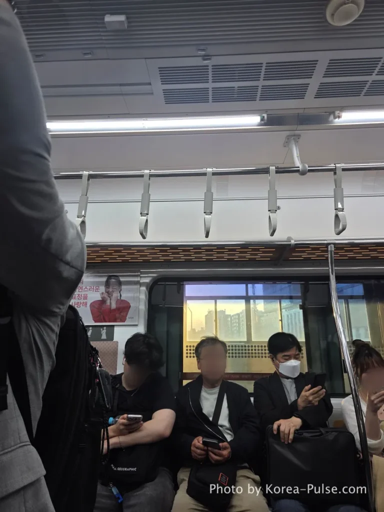 Inside Seoul Rush Hour: Why Korea's Subway System Feels Different 8 Seoul Metro passengers sitting in silence during evening commute, golden hour light glowing through the train window