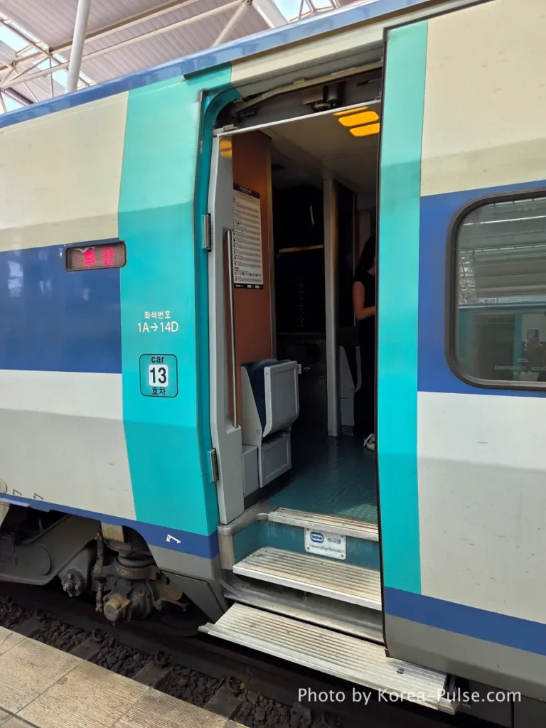 KTX train door entrance showing luggage rack and fold-down jump seat at Seoul Station