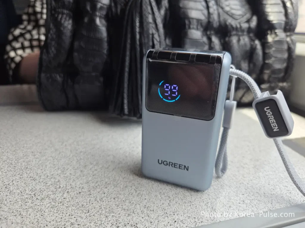 Ugreen portable power bank on KTX companion seat table showing full charge on KTX family trip Korea