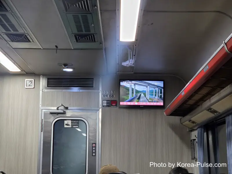 Dongdaegu to Andong Train: Riding Korea's Classic Mugunghwa 10 Mugunghwa train Car 2 ceiling TV screen showing railway footage Dongdaegu to Andong journey