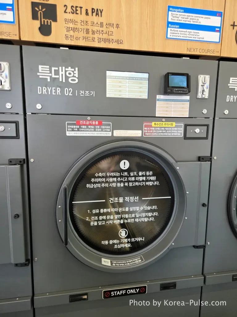 Large commercial dryer machine at Easy Wash Korean coin laundry showing front panel with digital display and payment terminal