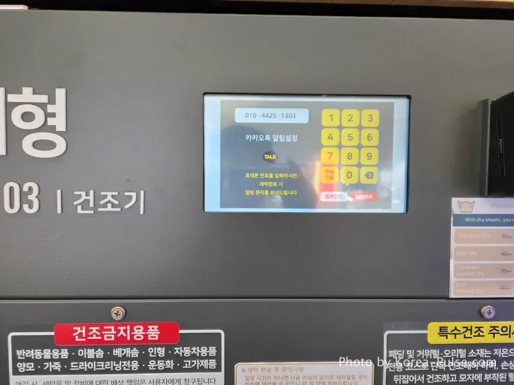 Dryer machine touchscreen panel at Easy Wash Korean coin laundry showing KakaoTalk notification phone number entry screen for cycle completion alert
