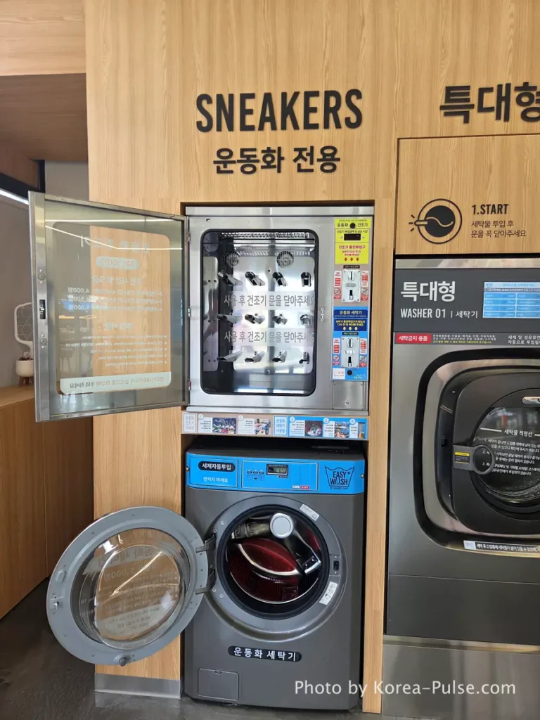 Empty sneaker washing and drying station at Easy Wash Korean coin laundry after completed cycle with shoes already collected showing vacant washer and dryer units