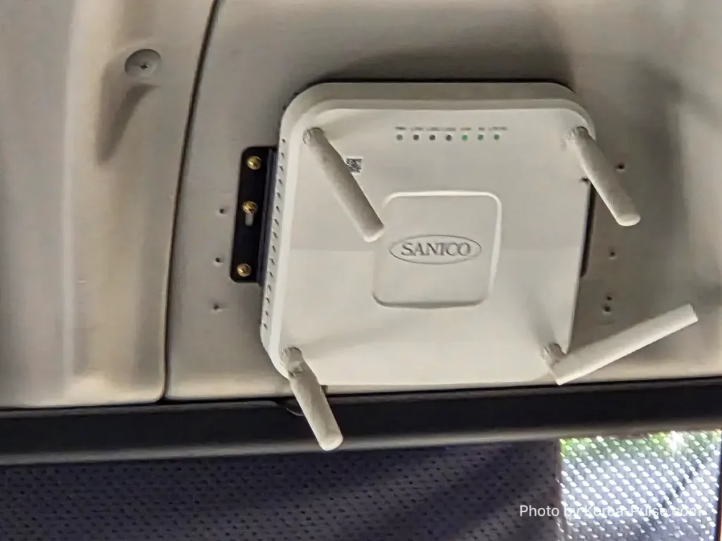 Korea public bus WiFi hardware SANICO industrial Wi-Fi 6 vehicle router with four antennas and green LED status lights mounted on ceiling of Airport Bus 3300