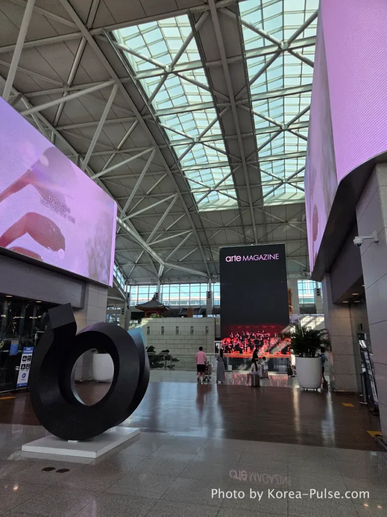 Incheon Airport Terminal 1 interior with large curved ceiling architecture and digital displays