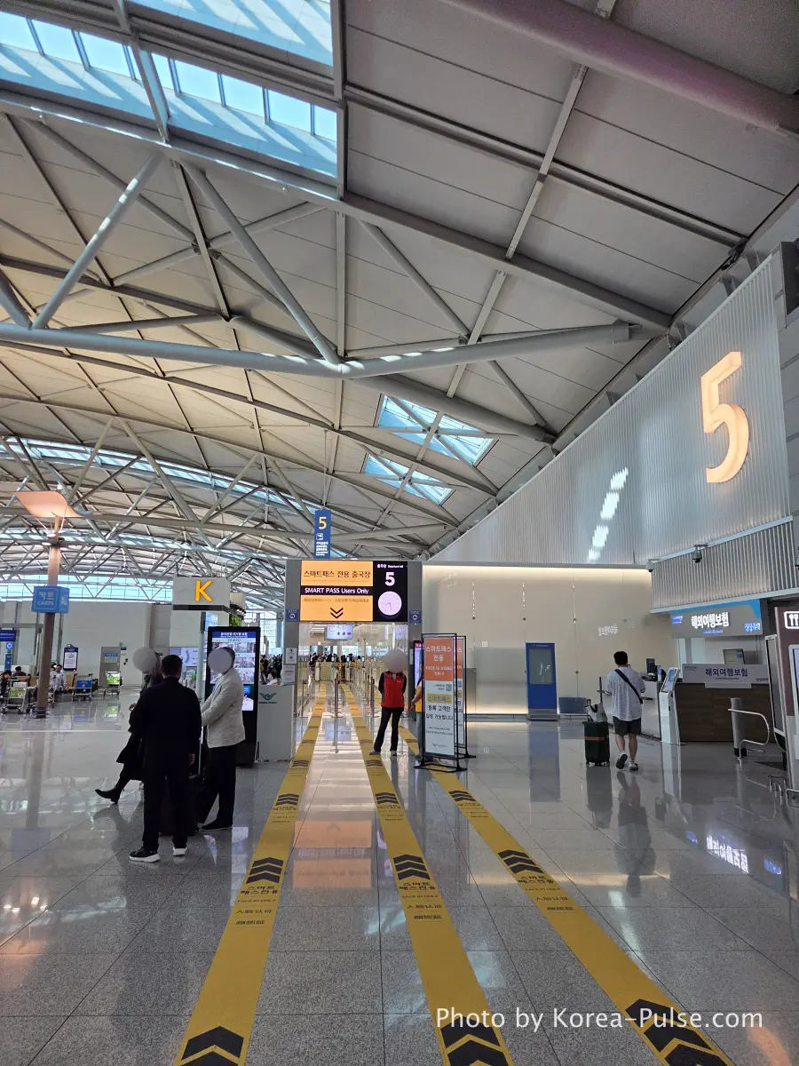 Incheon Airport Smartpass Users Only sign at Departure Gate 5 with yellow floor guide arrows and orange overhead signage Terminal 1