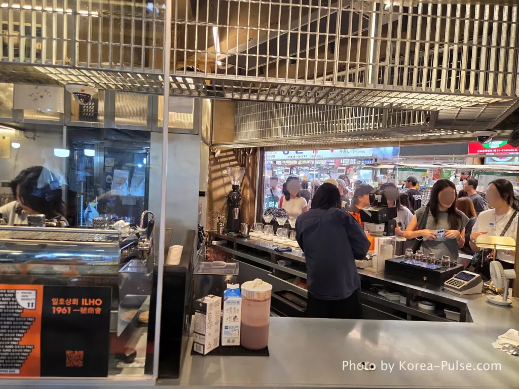 Ilho Sanghoe 일호상회 coffee bar interior at Gwangjang Market Seoul with baristas making pour over coffee and customers waiting