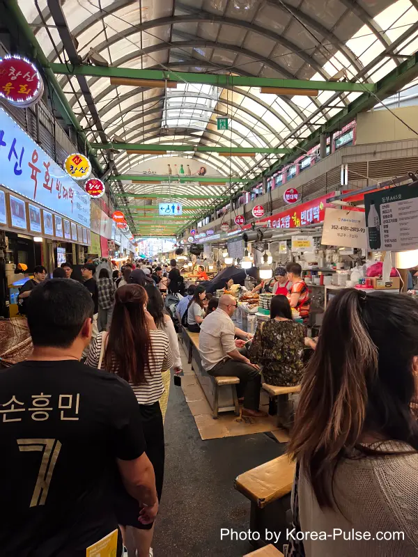 Gwangjang Market food alley East Gate direction long stretch stalls visitors eating weekday lunch