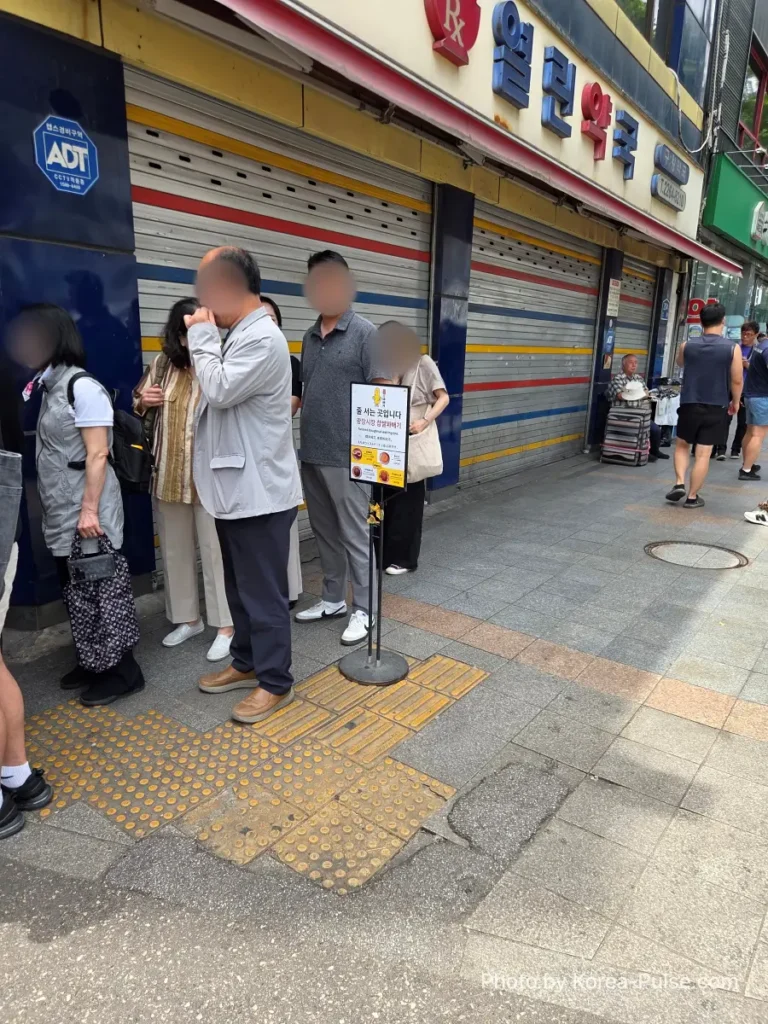 Gwangjang Market kkwabaegi queue stretching outside North Gate 2 onto the street Seoul