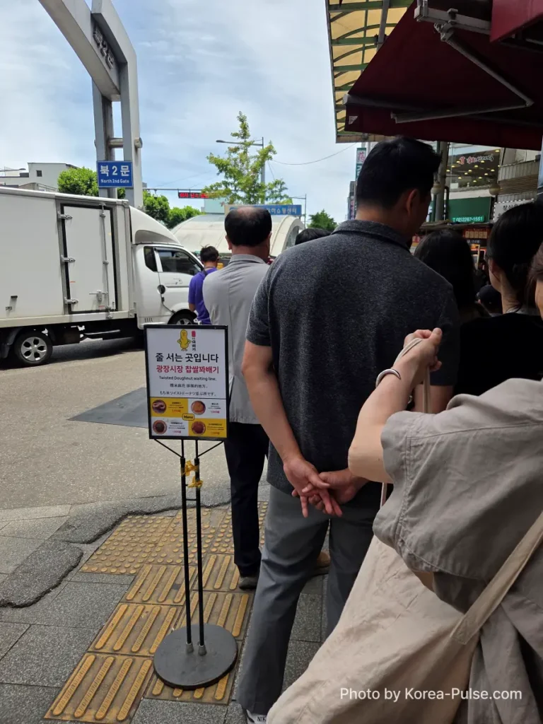Gwangjang Market kkwabaegi queue viewed from the back of the line looking toward stall entrance