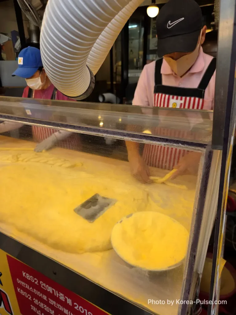 Gwangjang Market kkwabaegi staff making twisted donuts at prep counter with glutinous rice dough