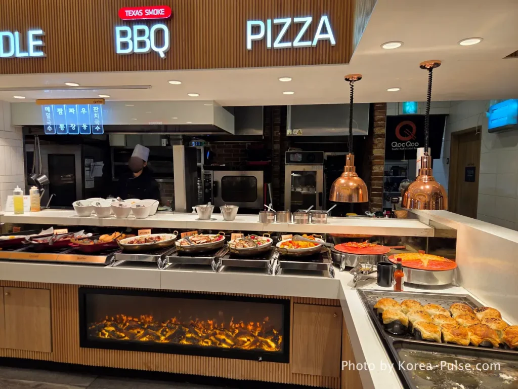 Pizza BBQ and noodle station signs at QooQoo buffet