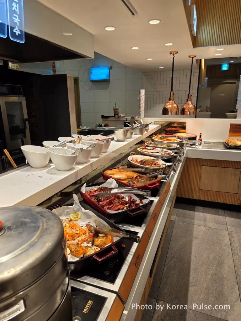 Korean BBQ zone with grilled meats and copper hoods at QooQoo buffet