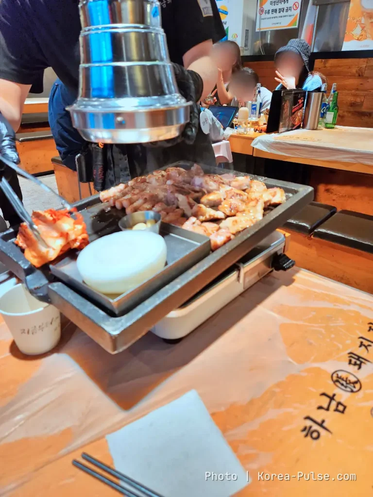 K-BBQ Etiquette Without the Anxiety: How to Grill, Share, and Read the Table Like a Local 2 Restaurant staff grilling Korean barbecue meat at a tabletop grill