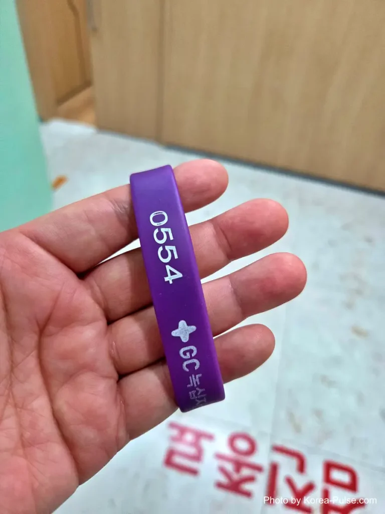 Purple RFID checkup wristband with an ID number, worn on a patient's wrist