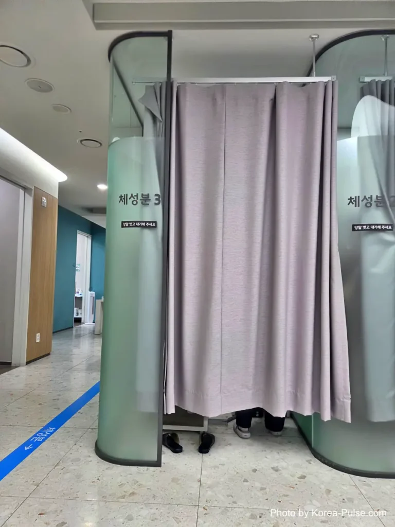 Row of curtained booths with teal walls used for body composition measurements at a health checkup center