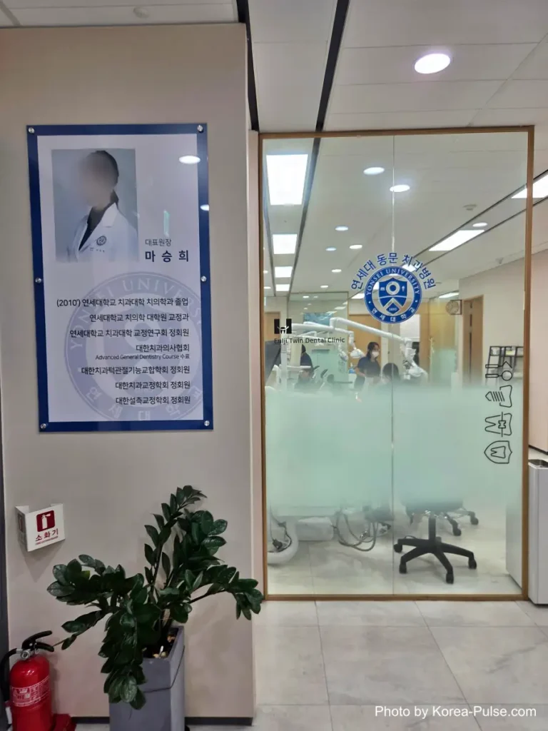 Entrance to a dental clinic with a doctor's portrait plaque displayed on the wall