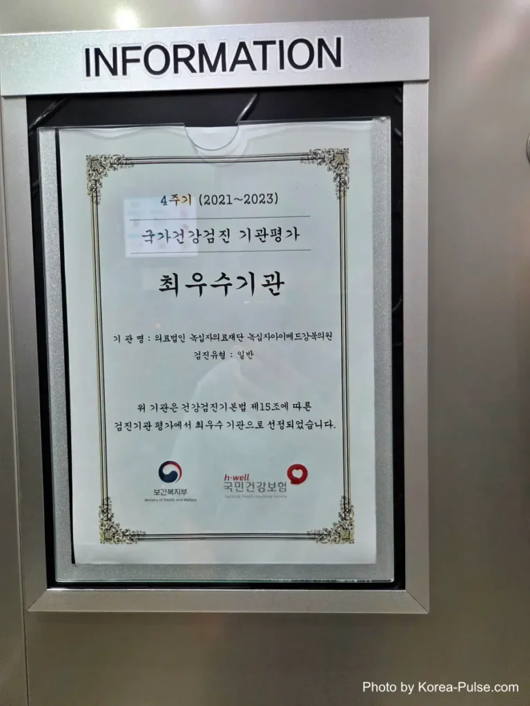 Framed certificate on a wall recognizing a health screening clinic as an excellent institution