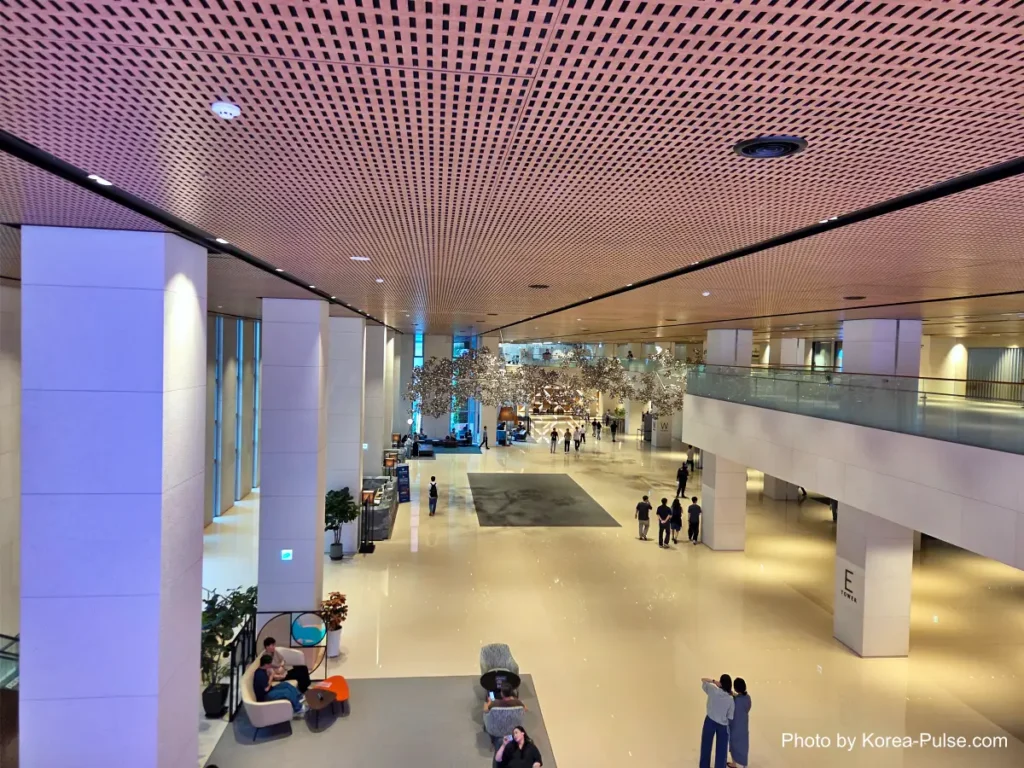 Spacious atrium lobby with people walking through, in the building housing a Seoul health checkup center