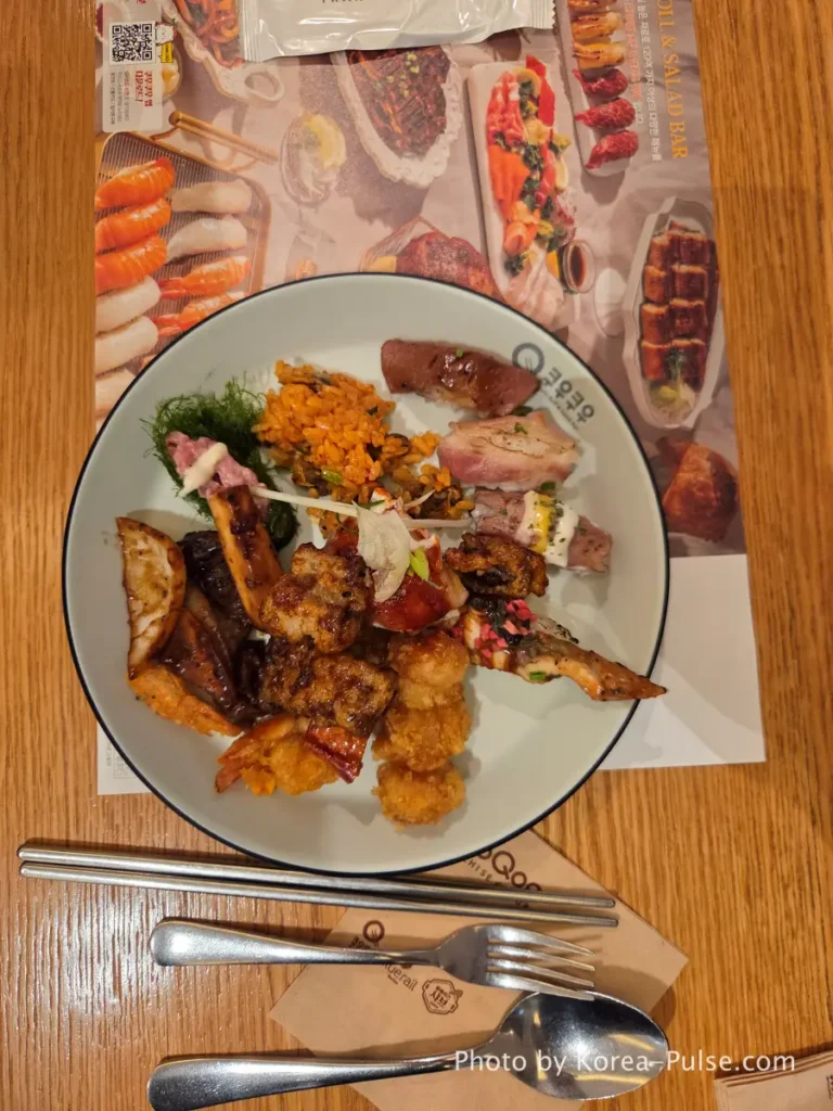 First plate with fried dishes sushi and samples at QooQoo Korean buffet
